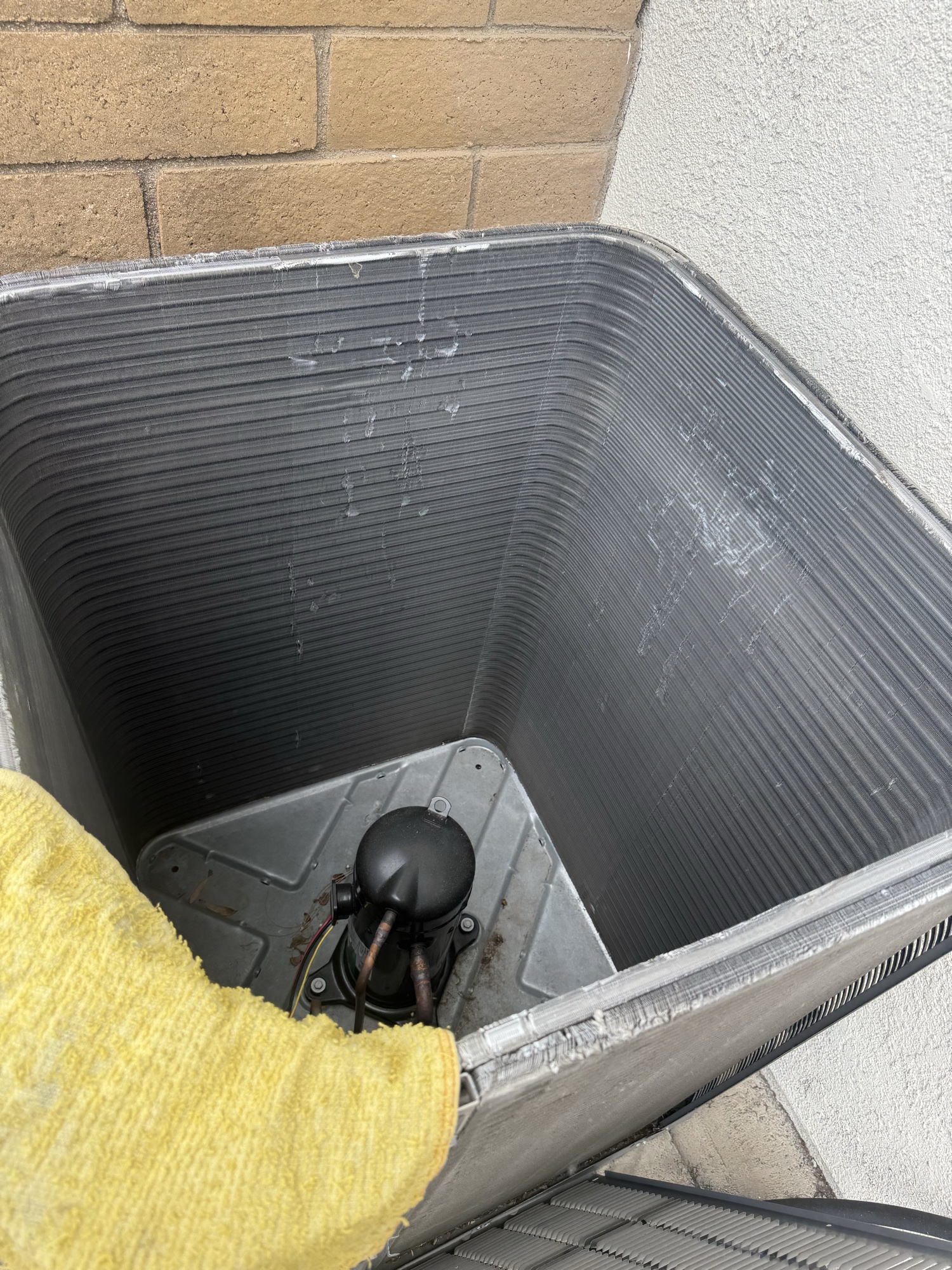 Inside condenser unit inspection showing compressor and fan motor